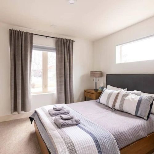 The master bedroom comes with a queen bed, a full en suite bath, and a lovely desk for reading or work. There is also a wall-mounted smart TV!
