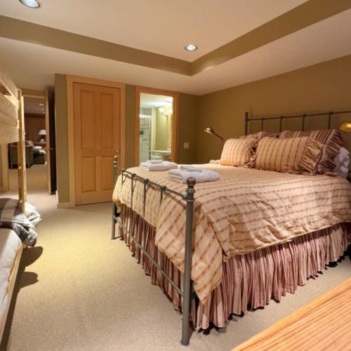 Bedroom #5, located in the basement, has a queen bed, twin-over-twin bunk bed, and an en suite bath.