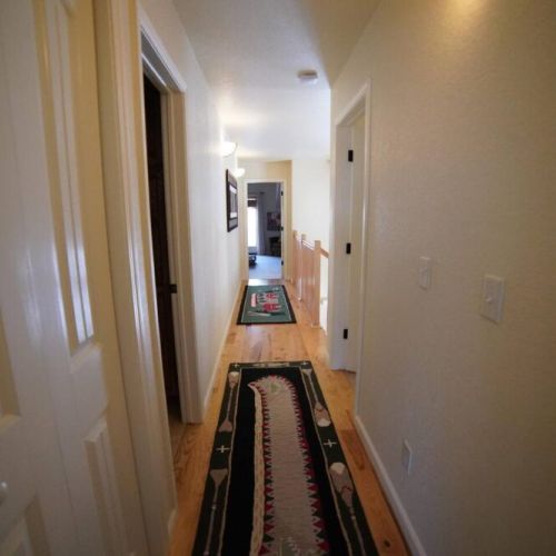 Hallway on second floor leads to the other bathroom and bedrooms.