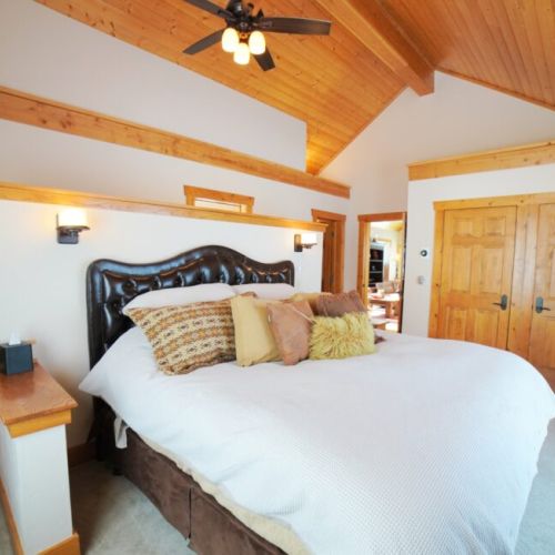 The master bedroom, located on the main floor of the home, features a king bed, an en suite bathroom, and a sauna.