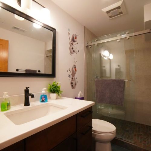 Both downstairs bedrooms share a bathroom with a spacious vanity and a large walk-in shower.