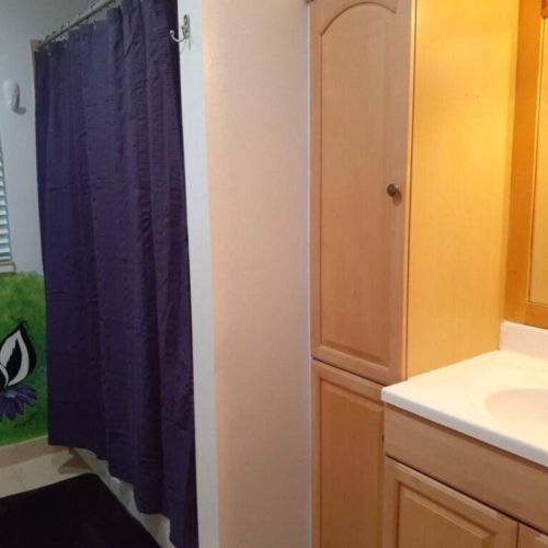 Bedrooms #2, #3, #4, and #5 share this downstairs bathroom, featuring a vanity and a tub/shower combo.