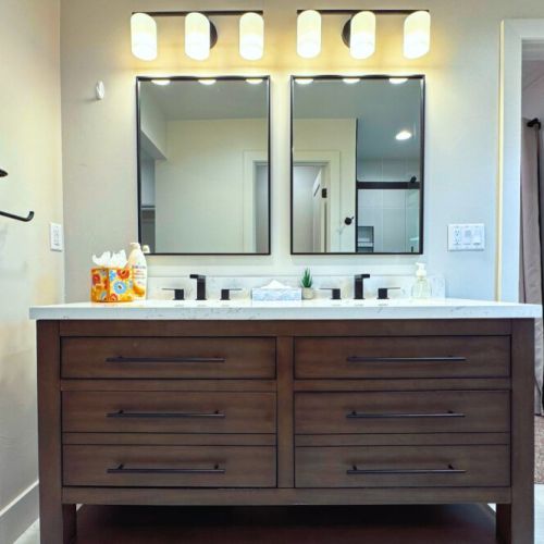 The primary en suite bathroom enjoys a step-in shower, a spacious double vanity, access to the walk-in closet, and a private water closet.
