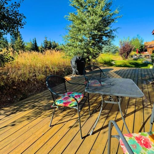 The backyard, which butts up against Ski Hill Road, has a cozy porch with a propane grill and comfy seating options.