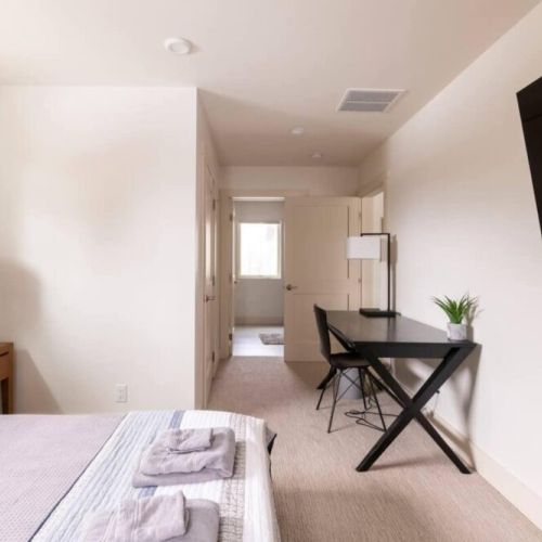 The master bedroom comes with a queen bed, a full en suite bath, and a lovely desk for reading or work. There is also a wall-mounted smart TV!