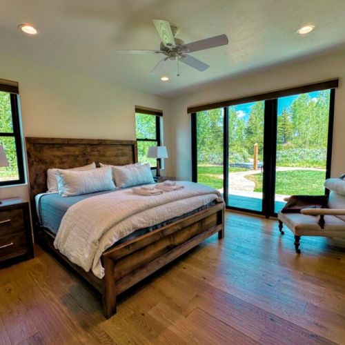 The ground-floor master bedroom enjoys a king bed, a large en suite bathroom, and direct access to the backyard (including a path directly to the hot tub).
